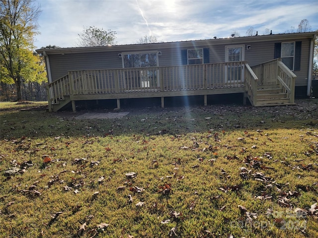 back of property with a lawn and a wooden deck