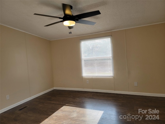 spare room with a textured ceiling, dark hardwood / wood-style flooring, ceiling fan, and crown molding