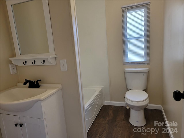 bathroom featuring wood-type flooring, vanity, toilet, and a bathing tub