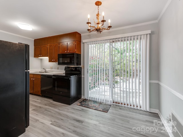 kitchen with light wood-type flooring, sink, black appliances, a chandelier, and hanging light fixtures