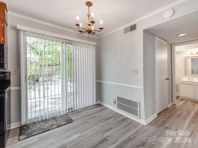 unfurnished dining area with crown molding, sink, light hardwood / wood-style floors, and an inviting chandelier