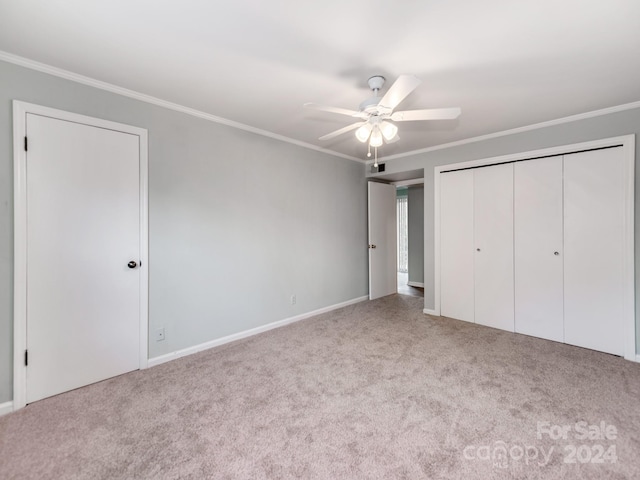 unfurnished bedroom featuring a closet, ceiling fan, crown molding, and light colored carpet