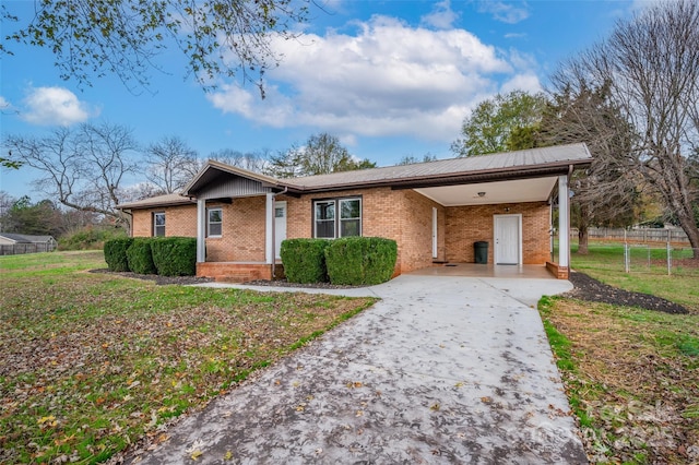 ranch-style home featuring a carport and a front yard