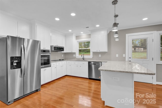 kitchen with white cabinetry, stainless steel appliances, decorative light fixtures, and light stone countertops