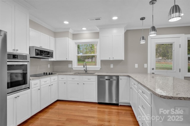 kitchen featuring appliances with stainless steel finishes, decorative light fixtures, sink, white cabinets, and kitchen peninsula