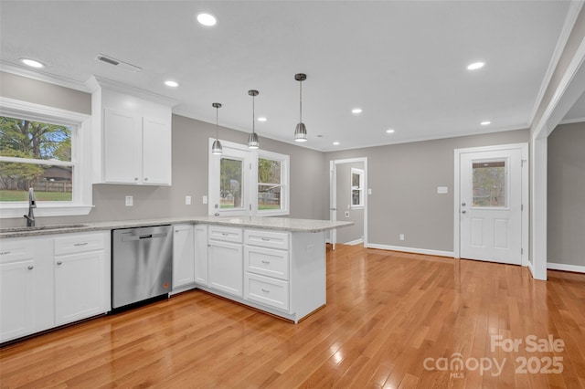 kitchen with stainless steel dishwasher, decorative light fixtures, sink, and white cabinets