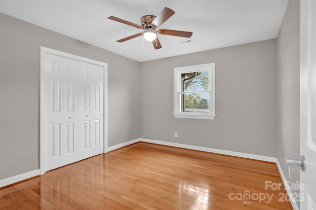 unfurnished bedroom with ceiling fan, a closet, and light hardwood / wood-style flooring