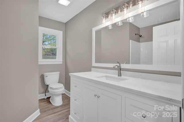 bathroom with hardwood / wood-style flooring, vanity, a shower, and toilet