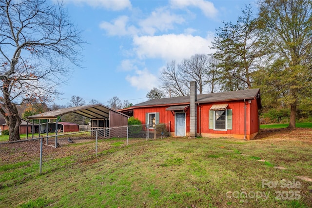 rear view of property featuring a carport and a lawn