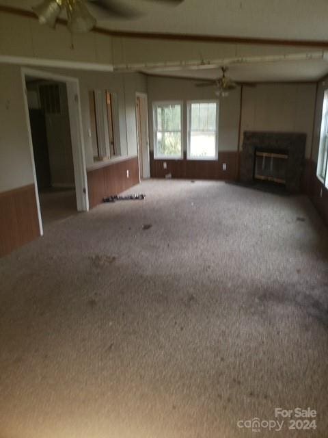 unfurnished living room featuring carpet flooring and ceiling fan