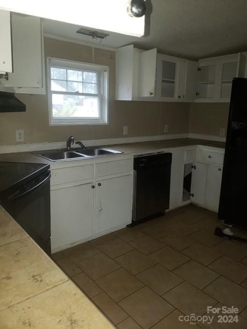 kitchen with dark tile patterned floors, exhaust hood, sink, black appliances, and white cabinets