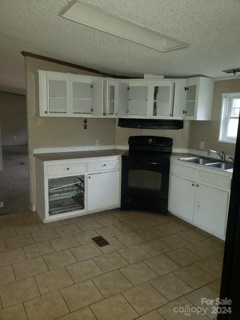 kitchen with a textured ceiling, ventilation hood, sink, black range, and white cabinetry