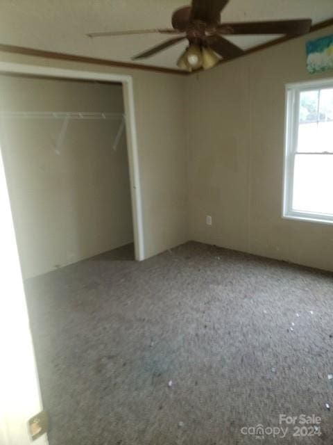 unfurnished bedroom with ceiling fan and a closet