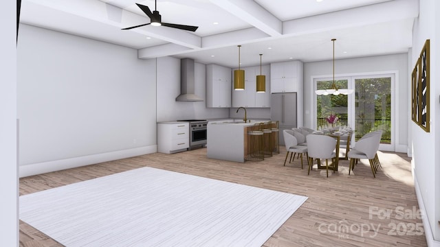 kitchen with high end stove, light wood-style flooring, a sink, wall chimney range hood, and beamed ceiling