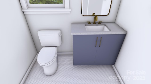 half bathroom with baseboards, vanity, and toilet