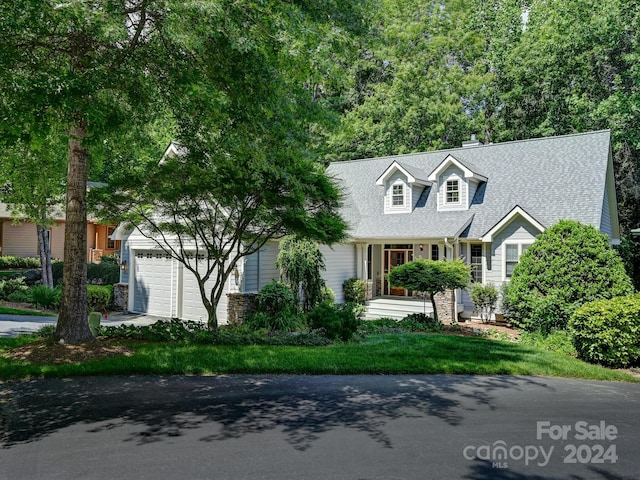 cape cod home featuring a garage