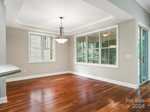 unfurnished dining area featuring a raised ceiling, crown molding, and dark hardwood / wood-style floors