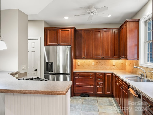 kitchen featuring ceiling fan, sink, backsplash, pendant lighting, and appliances with stainless steel finishes