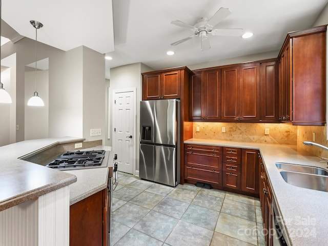 kitchen featuring ceiling fan, sink, backsplash, stainless steel fridge, and pendant lighting