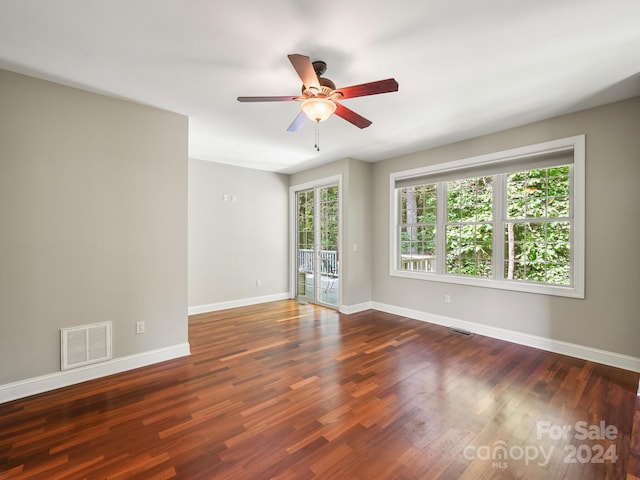 empty room with ceiling fan and dark wood-type flooring