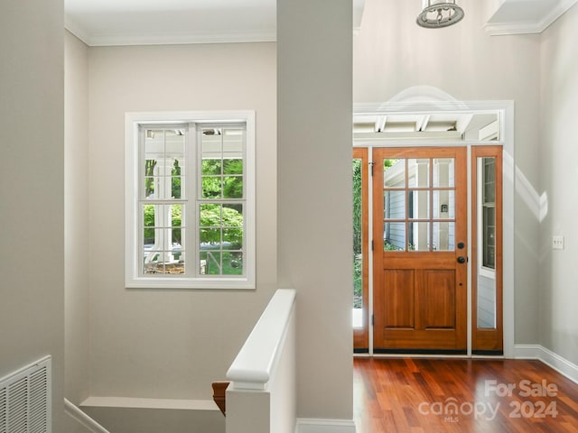 foyer with wood-type flooring and ornamental molding