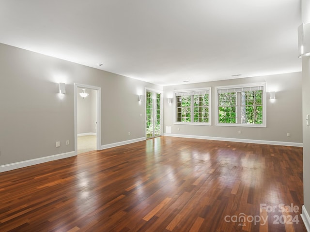 unfurnished room with dark wood-type flooring