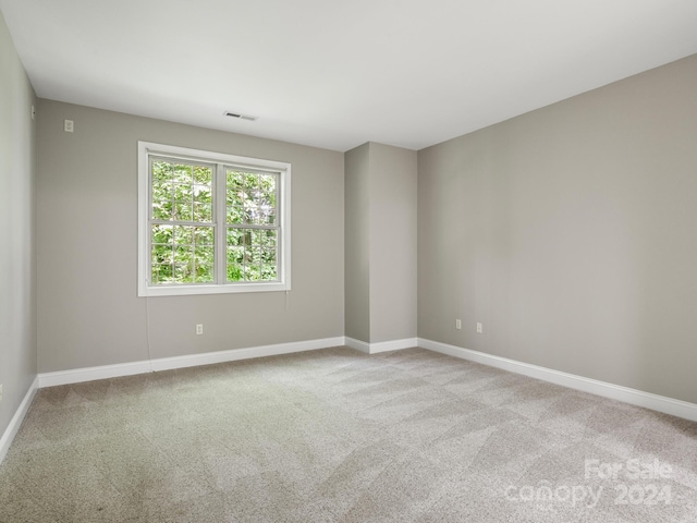 unfurnished room featuring light colored carpet