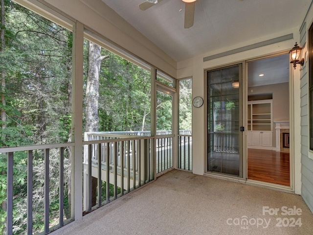 unfurnished sunroom with ceiling fan and plenty of natural light