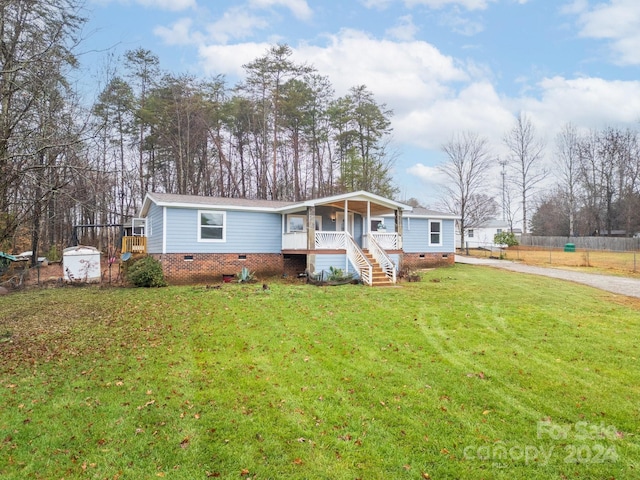 view of front of home with a storage unit, a porch, and a front lawn