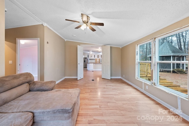 living room featuring a textured ceiling, light wood-type flooring, ceiling fan, and ornamental molding