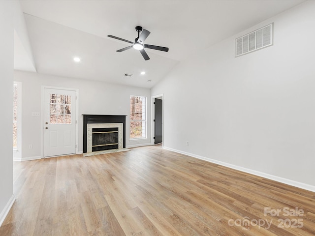 unfurnished living room featuring a fireplace, light hardwood / wood-style floors, ceiling fan, and vaulted ceiling