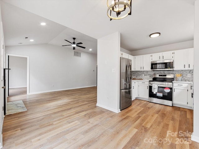 kitchen featuring backsplash, light hardwood / wood-style floors, white cabinets, and appliances with stainless steel finishes