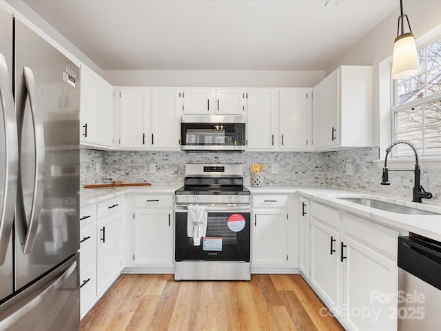 kitchen with appliances with stainless steel finishes, sink, and white cabinets