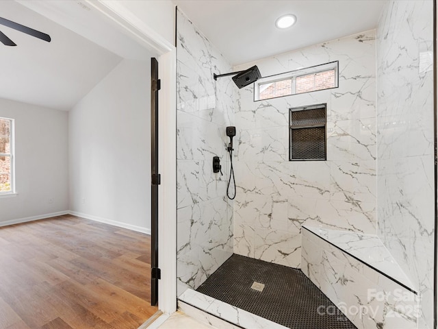 bathroom with a tile shower, wood-type flooring, and ceiling fan