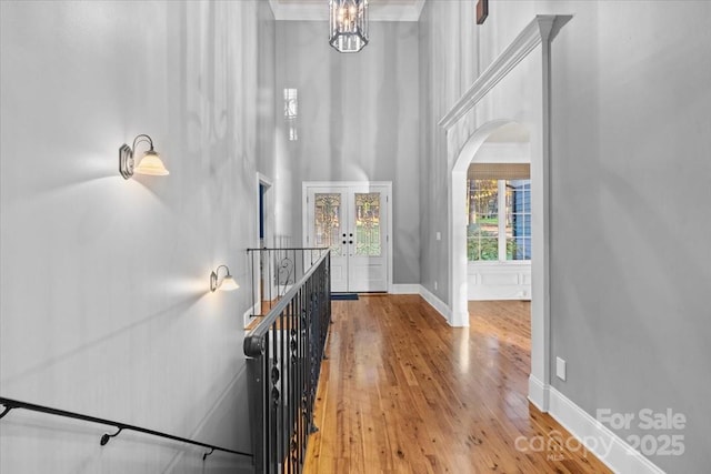 interior space with french doors, a towering ceiling, and light hardwood / wood-style flooring