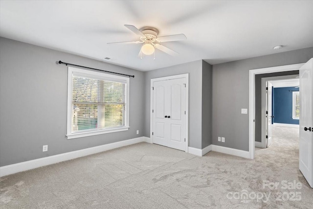 unfurnished bedroom with ceiling fan, light colored carpet, and a closet