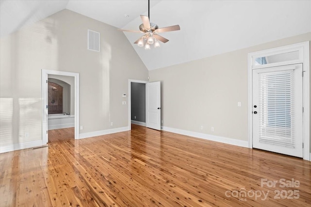 unfurnished living room with hardwood / wood-style flooring, ceiling fan, and high vaulted ceiling