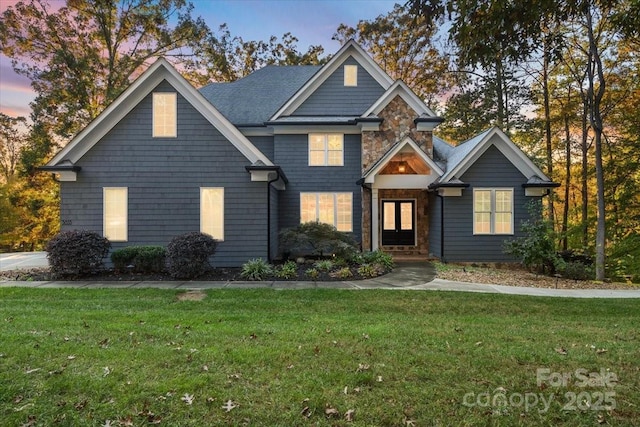 view of front of house with stone siding and a front lawn