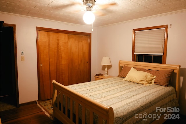 bedroom featuring ceiling fan, dark hardwood / wood-style floors, and crown molding