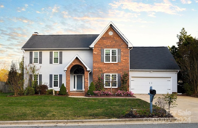 view of front of property featuring a front lawn and a garage