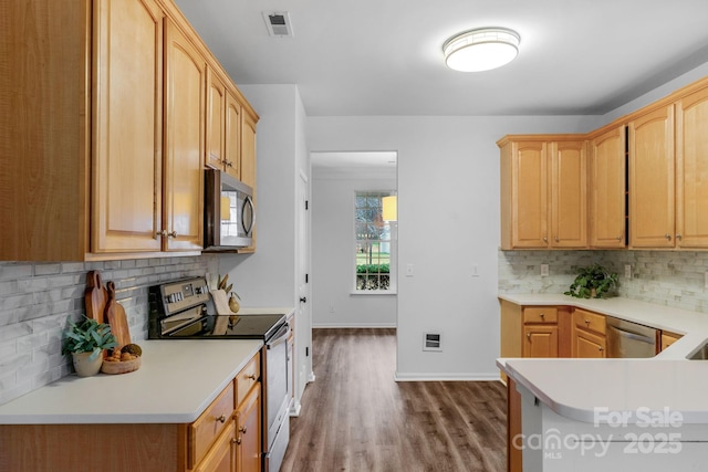 kitchen featuring tasteful backsplash, appliances with stainless steel finishes, wood-type flooring, and light brown cabinets