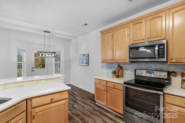 kitchen with pendant lighting, dark hardwood / wood-style flooring, stainless steel appliances, tasteful backsplash, and light brown cabinetry