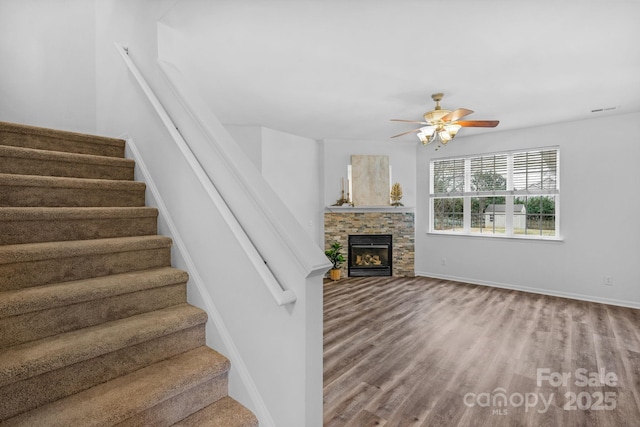 unfurnished living room with hardwood / wood-style flooring, a fireplace, and ceiling fan