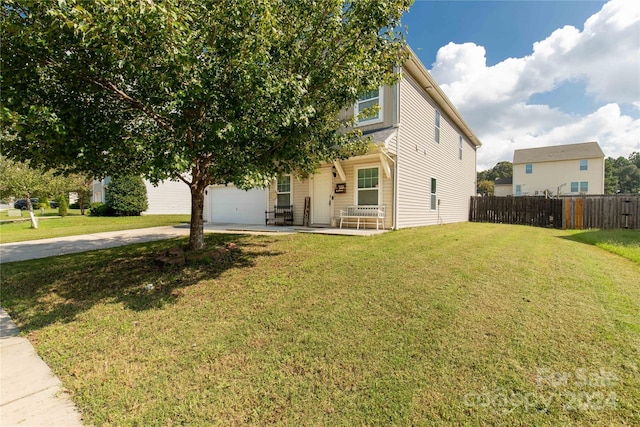 view of property hidden behind natural elements with a front lawn and a garage