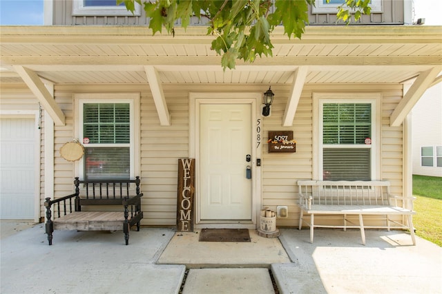 doorway to property with a porch and a garage