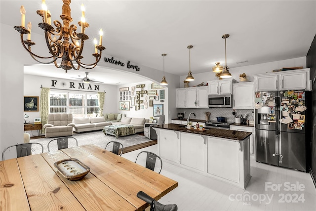 kitchen featuring a center island, tasteful backsplash, a breakfast bar area, white cabinets, and appliances with stainless steel finishes