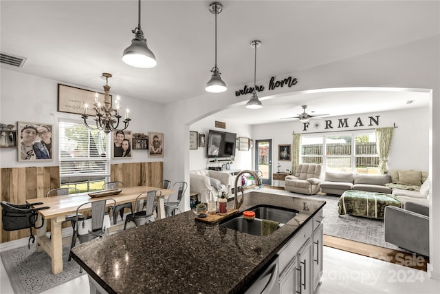 kitchen featuring a wealth of natural light, a kitchen island with sink, and light hardwood / wood-style floors