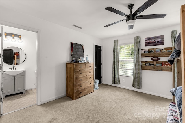 bedroom featuring ceiling fan, sink, light carpet, and connected bathroom