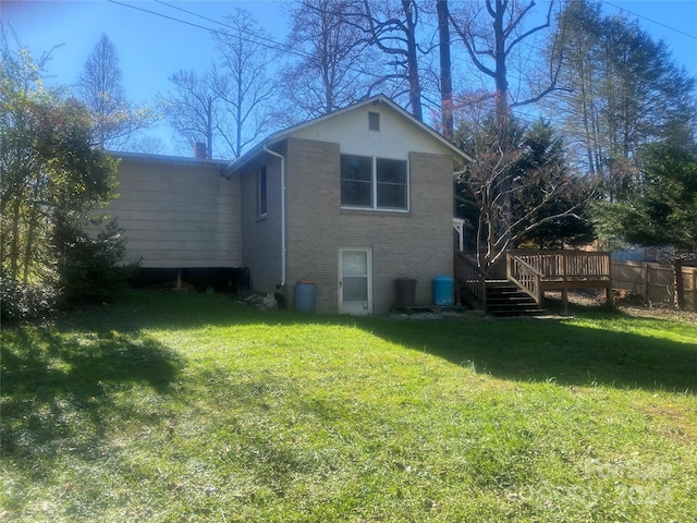 rear view of house featuring a deck and a lawn