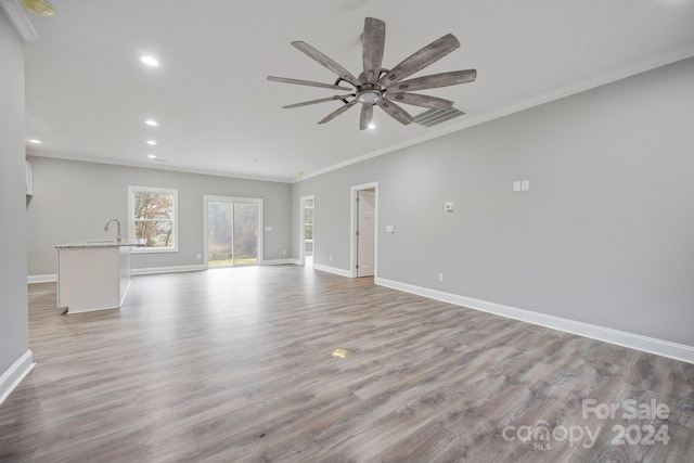 unfurnished living room featuring ceiling fan, light wood-type flooring, and crown molding